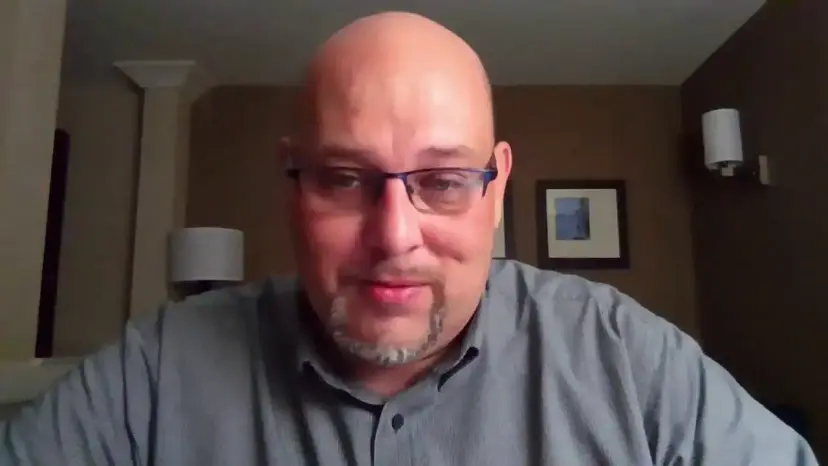 Daniel Miller speaks on a video call from a hotel room while on the road.