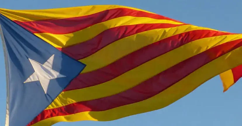 The Catalan independence flag, a white star on a blue triangle with red and yellow stripes, waving.