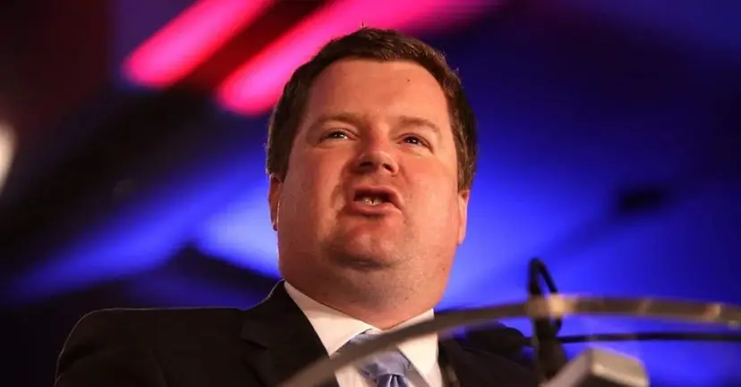 Erick Erickson speaking at a podium under colorful stage lights.