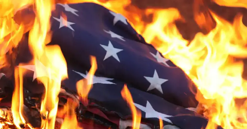 An American flag burning in bright orange flames.