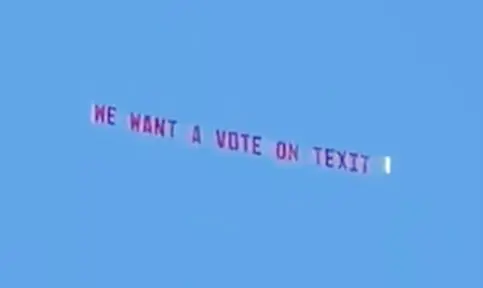 Aerial banner reading 'We want a vote on TEXIT' against a clear blue sky