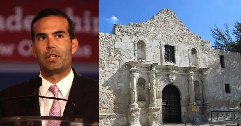 A dark haired man in a suit speaking at a podium beside the stone facade of the Alamo church.