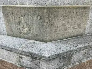 Close view of the carved stone base of the San Jacinto Monument, with the name and a star engraved.