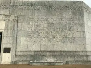 Engraved stone wall at the base of the San Jacinto Monument, covered in carved historical text.