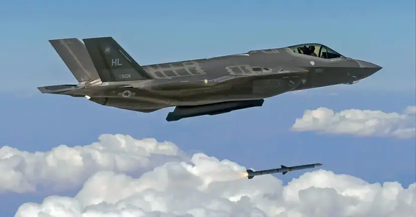 An F-35 fighter jet flying above the clouds as a missile launches beneath it.