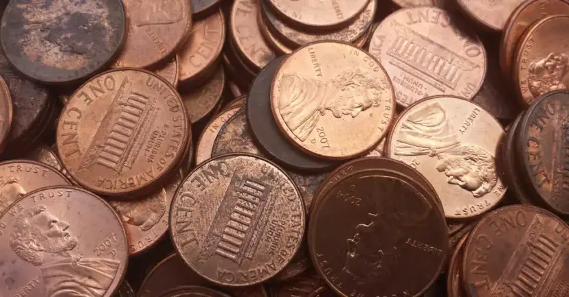 A close up pile of copper U.S. pennies, some worn and darkened with age.