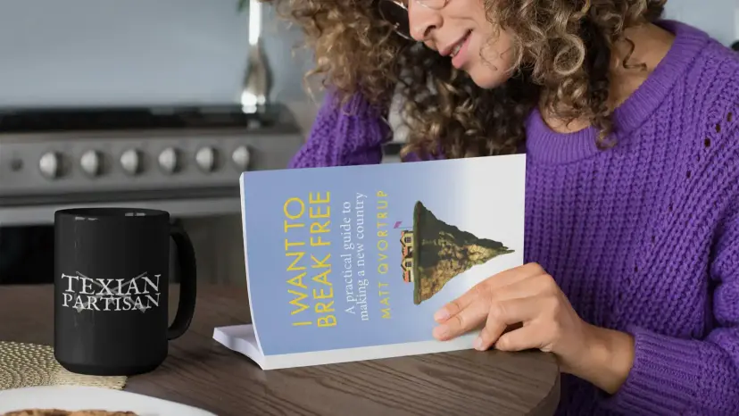 Woman in a purple sweater holding the book 'I Want to Break Free' beside a Texian Partisan mug