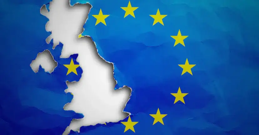 An outline of Great Britain torn out of a blue European Union flag with gold stars.
