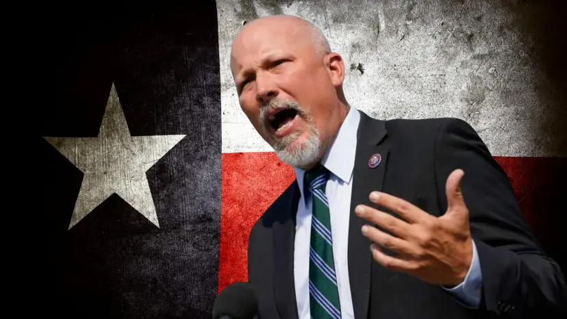 Gray-bearded congressman speaking forcefully in front of a weathered Texas flag
