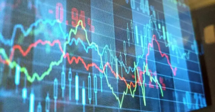 Stock market line and candlestick charts glowing on a trading screen.