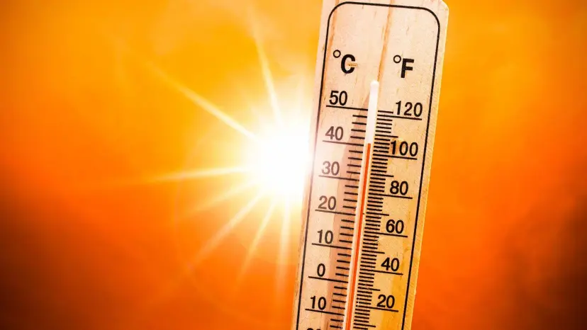 Thermometer reading above 40 degrees Celsius against a blazing orange sun.