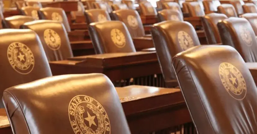 Rows of brown leather chairs embossed with the Seal of the State of Texas in a legislative chamber.