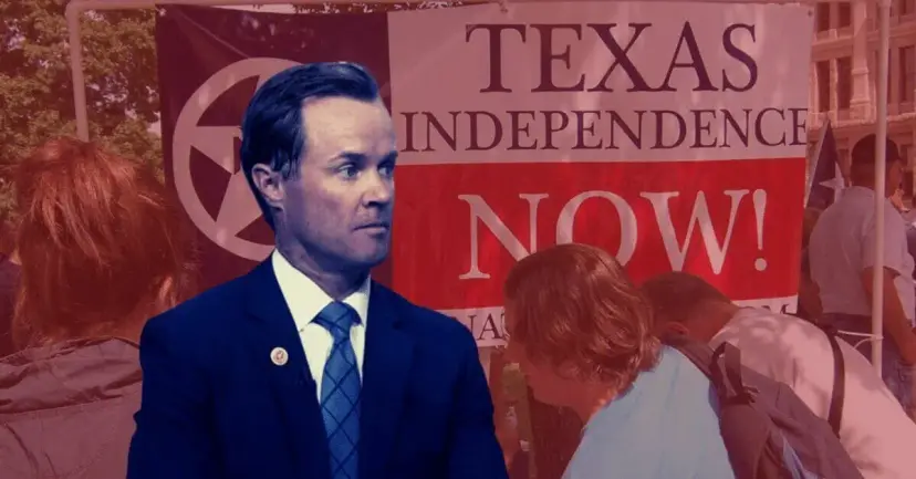 A man in a navy suit in front of a 'Texas Independence Now!' banner at a rally, tinted red.