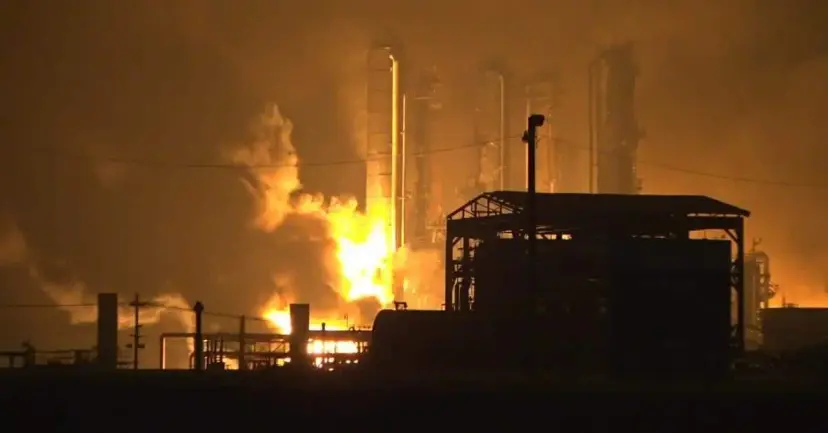 Flames and smoke rise from a chemical plant at night after an explosion.