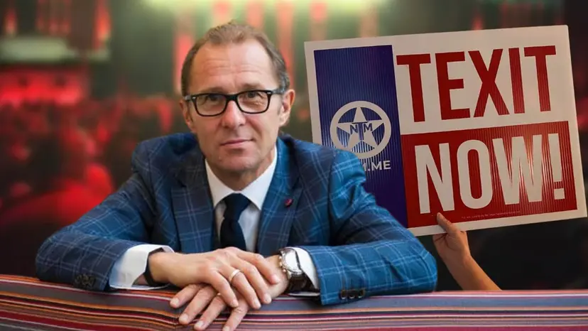 A man in glasses and a blue plaid blazer leaning on a railing beside a 'TEXIT Now!' sign.