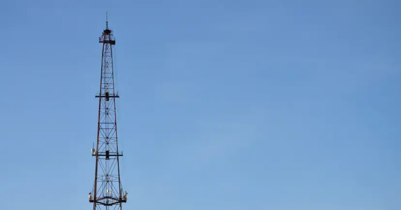 A tall steel radio tower against a clear blue sky.