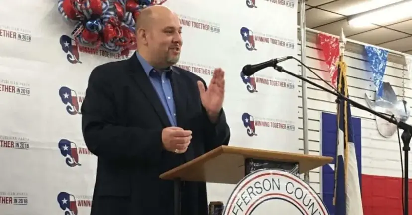 Daniel Miller speaking at a podium at a Jefferson County Republican event, in front of a campaign backdrop.