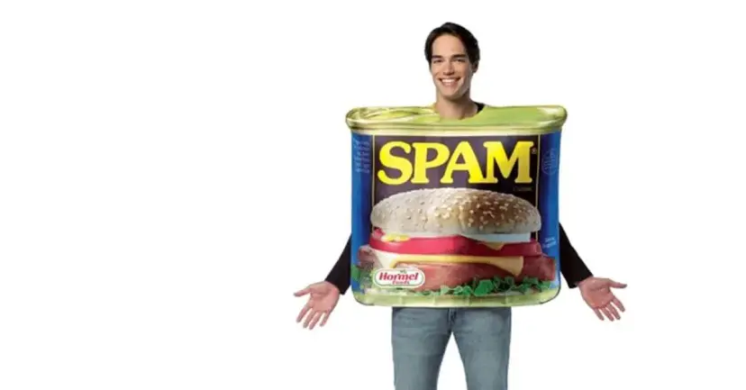 A smiling man wearing a costume shaped like a can of Spam.