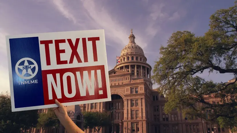 Hand holding a TEXIT NOW sign in front of the Texas Capitol under a cloudy sky