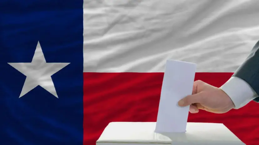 A hand drops a paper ballot into a box in front of a Texas flag.