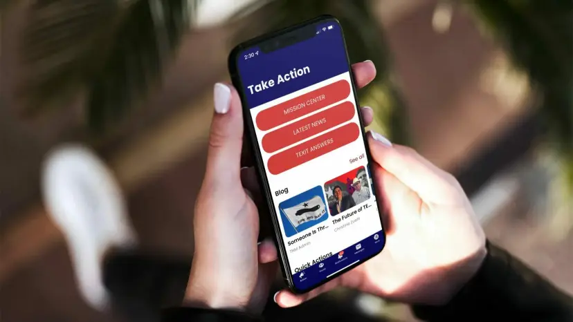 Hands holding a smartphone showing a mobile app's 'Take Action' screen with red menu buttons.