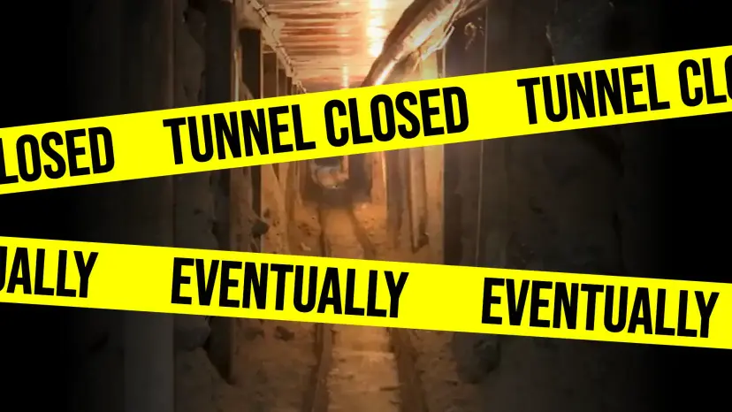 Dimly lit smuggling tunnel crossed by yellow tape reading 'Tunnel Closed' and 'Eventually'