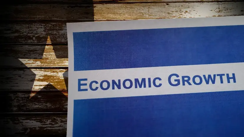Paper reading 'Economic Growth' laid over a weathered wooden Texas flag with a white star.