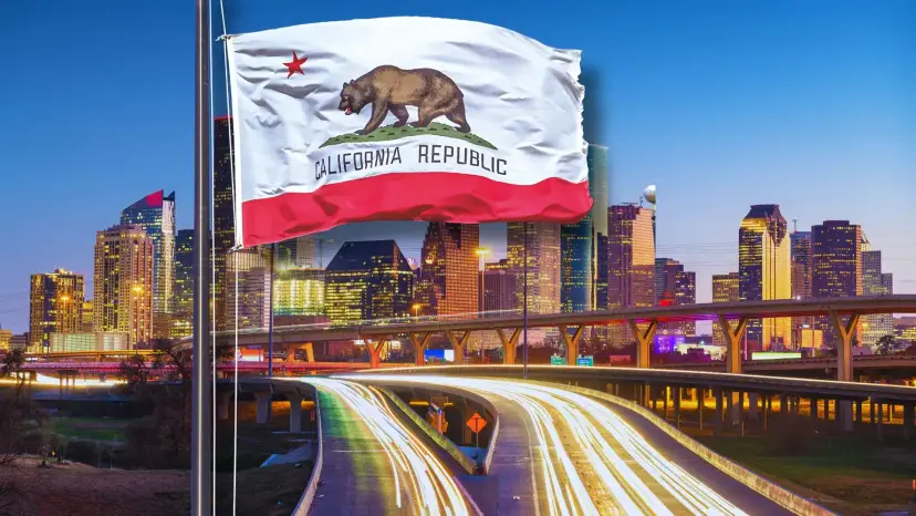 California Republic flag flying over the Houston skyline at dusk, with streaks of light from highway traffic.