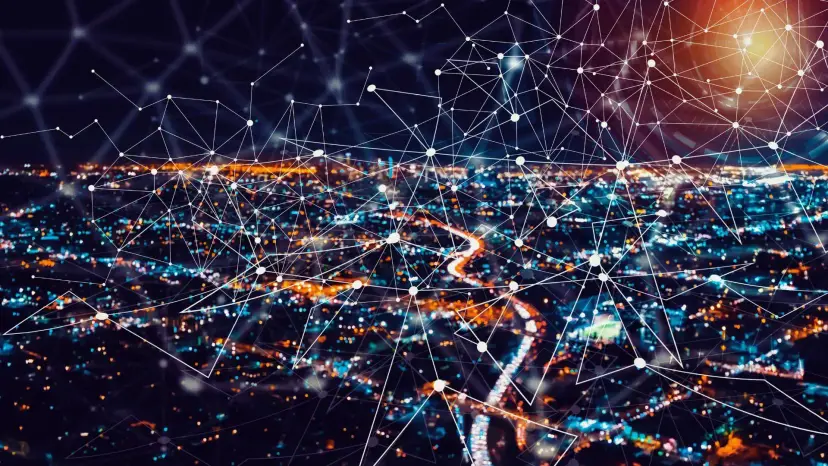 Nighttime aerial view of city lights overlaid with a web of connected network lines.