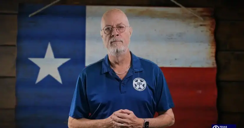 A bearded man in a blue TNM polo stands in front of a Texas flag painted on corrugated metal.