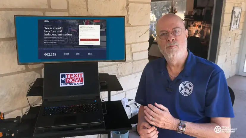 A bearded man in a TNM polo beside a monitor showing the thetnm.org homepage and a laptop showing TEXIT Now.