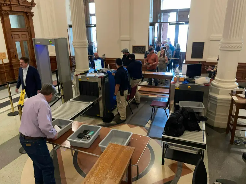 Visitors pass through the metal detector and bag screening at a Texas Capitol entrance.