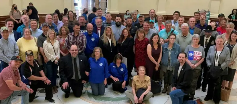 Dozens of Texas Nationalist Movement supporters pose for a group photo in the Texas Capitol rotunda.