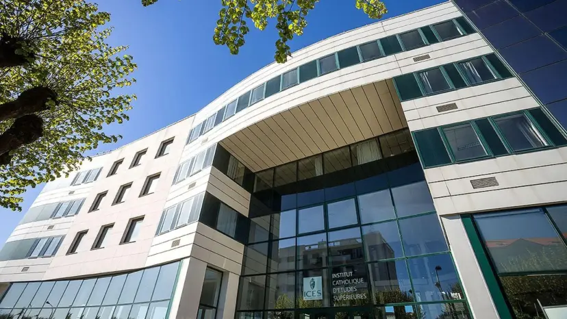 Modern glass and white stone building of the Institut Catholique d'Etudes Superieures in France under a blue sky