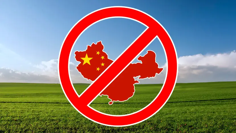 Red prohibition sign over a map of China against a green field and blue sky