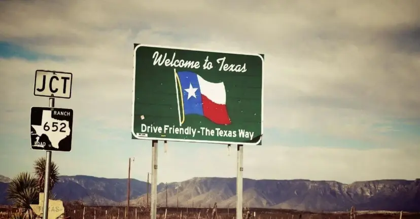 Green 'Welcome to Texas' road sign with a Texas flag beside a Ranch Road 652 junction marker.