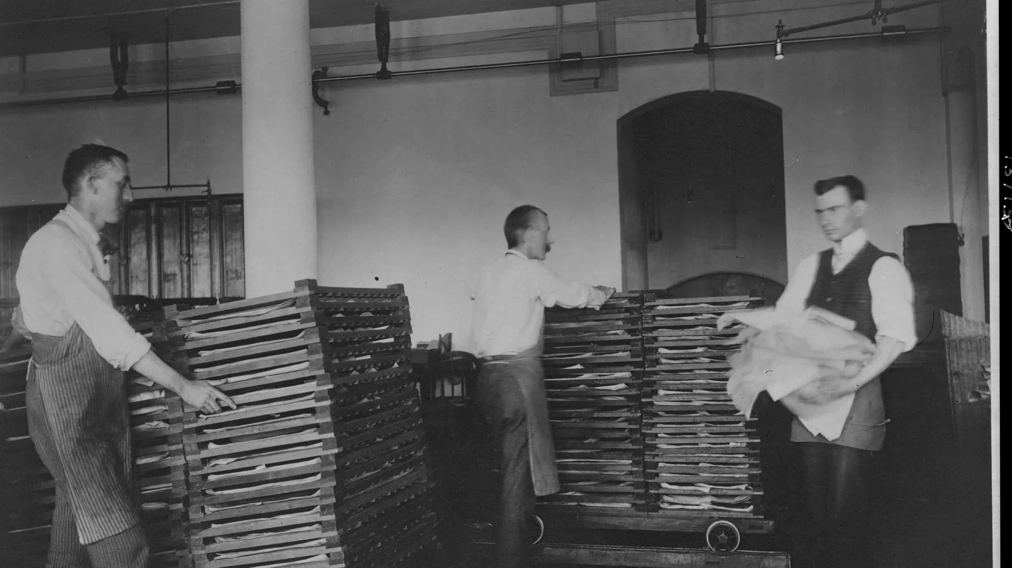Workers moving sheets of newly printed currency at the Bureau of Engraving and Printing