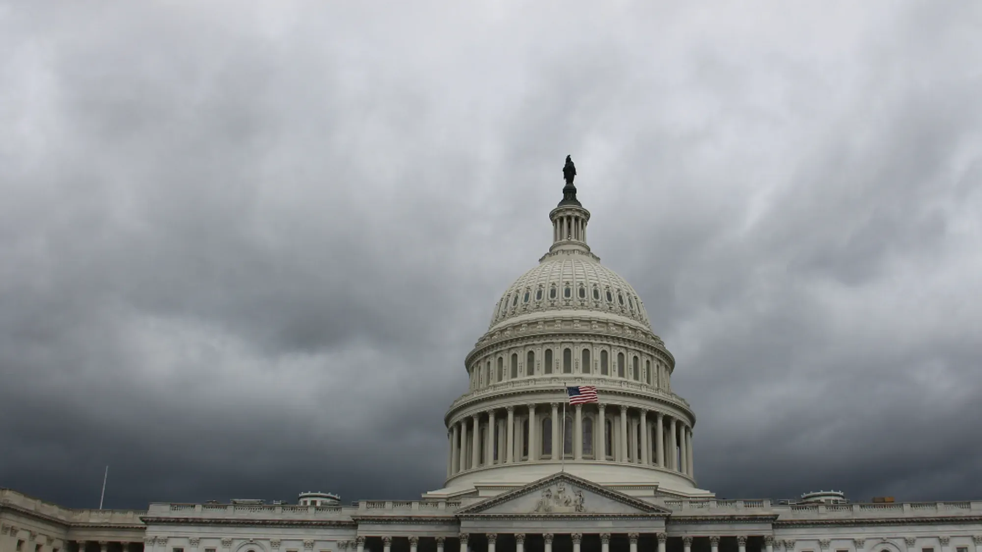 The Capitol dome in Washington under dark storm clouds
