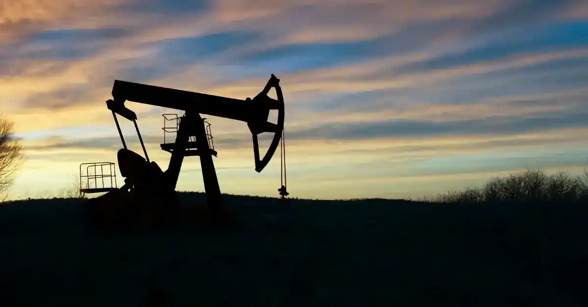 texas-oil Silhouette of an oil pumpjack in a field against a sunset sky.
