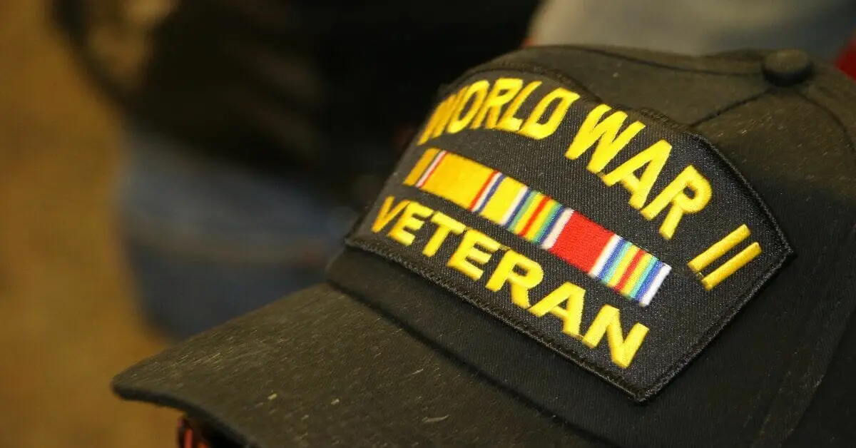 A black cap with a 'World War II Veteran' patch and a service ribbon.