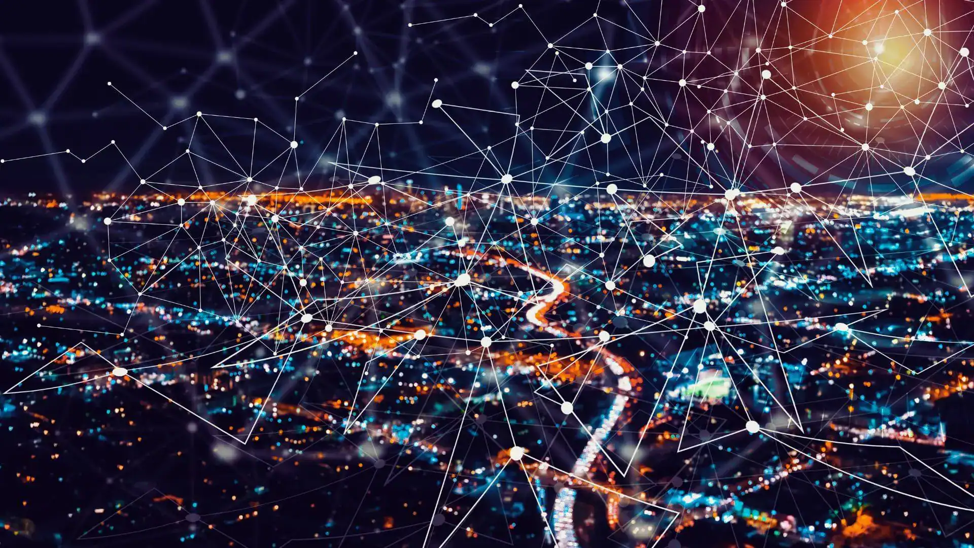 Nighttime aerial view of city lights overlaid with a web of connected network lines.